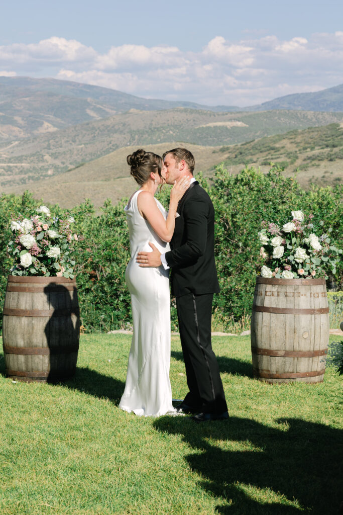 bride and groom having their first kiss in front of park city mountains